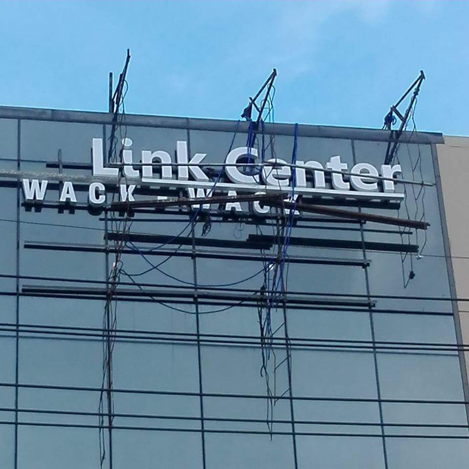 Damaged acrylic building signage for Link Center WACK-WACK in Mandaluyong with bent frame and exposed wires by M&G Global Ads.